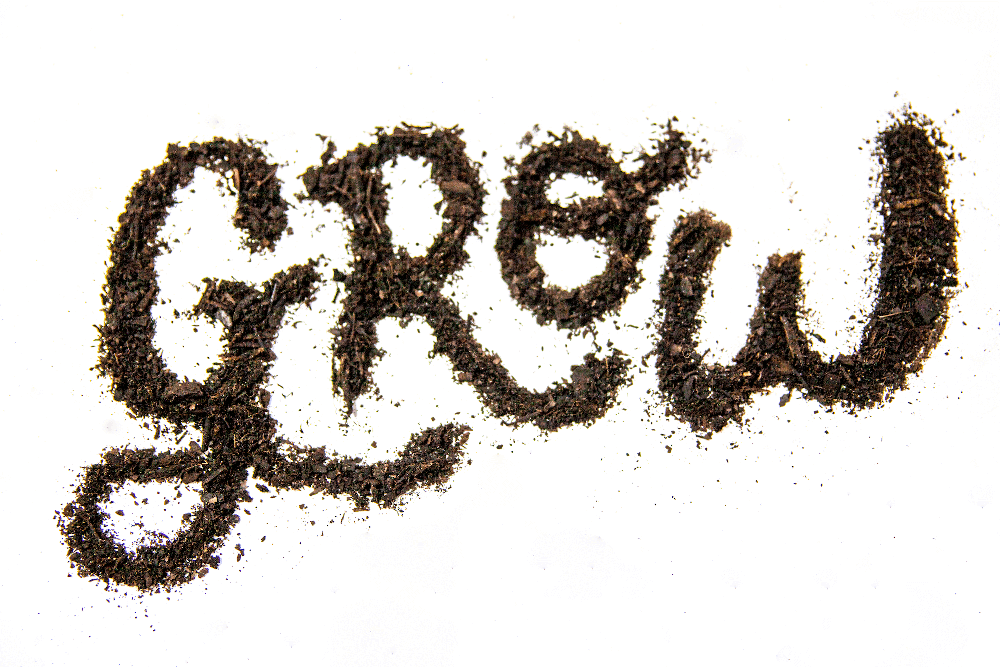 The word Grow is shown made from dark brown soil in cursive form on a white background
