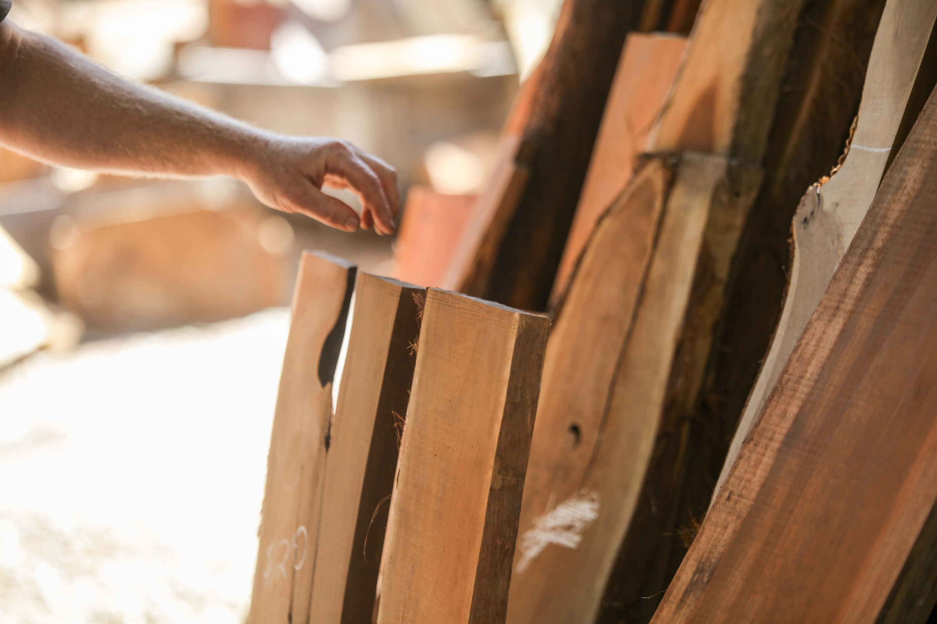 A photo of a man's hand selected a piece of wood from the salvaged wood business nearby - photo shot by me